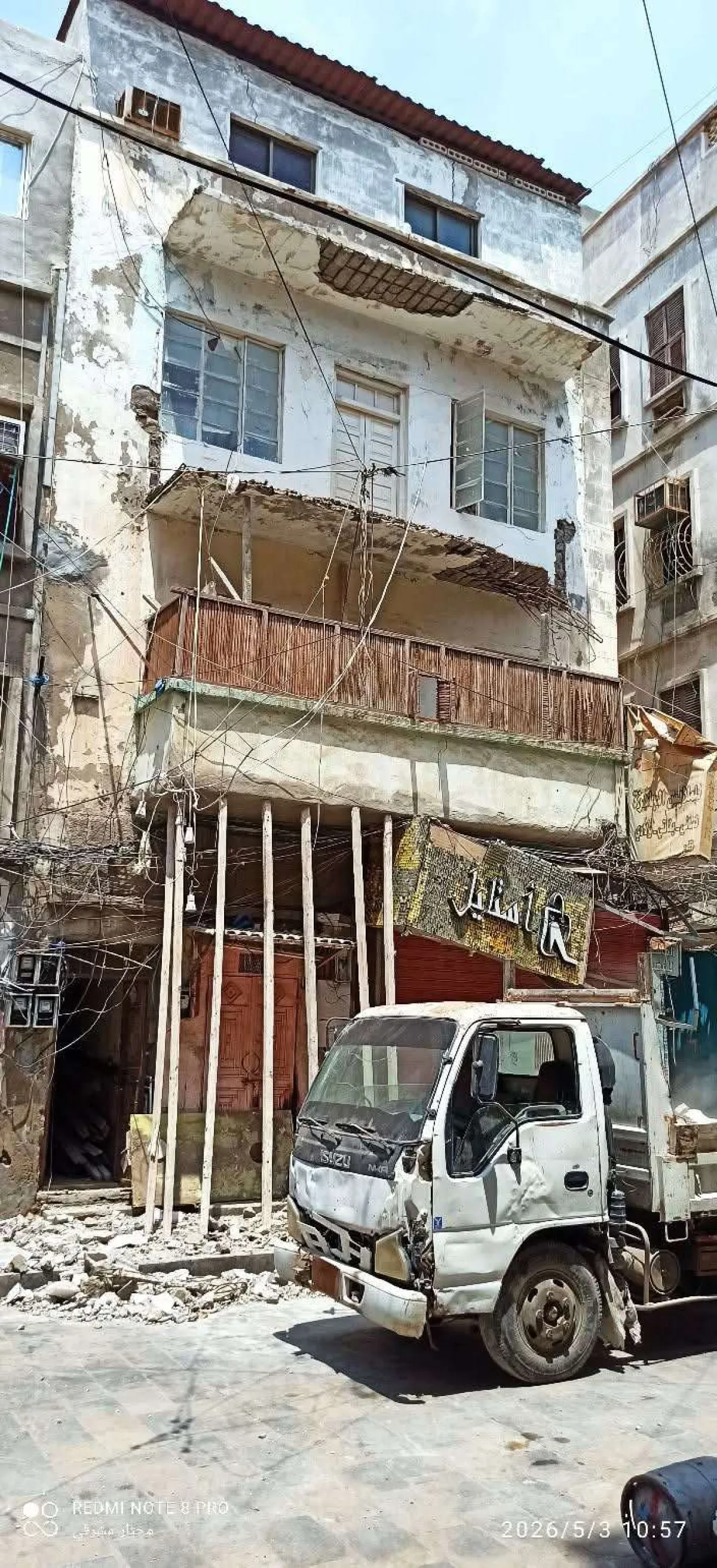 أشغال صيرة يزيل بلكونة مهددة بالانهيار بمبنى سكني في احد اسواق المديرية